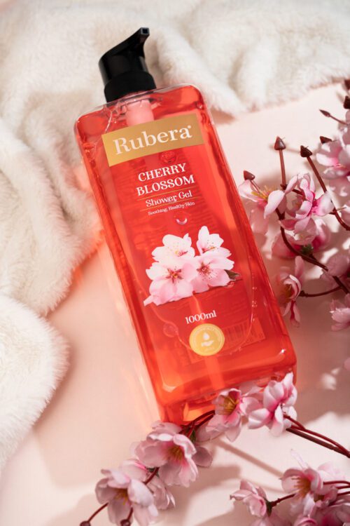 Rubera Cherry Blossom Shower Gel – 1000ml bottle with a floral cherry blossom-themed label, placed against a soft pink background with cherry blossoms in the frame.